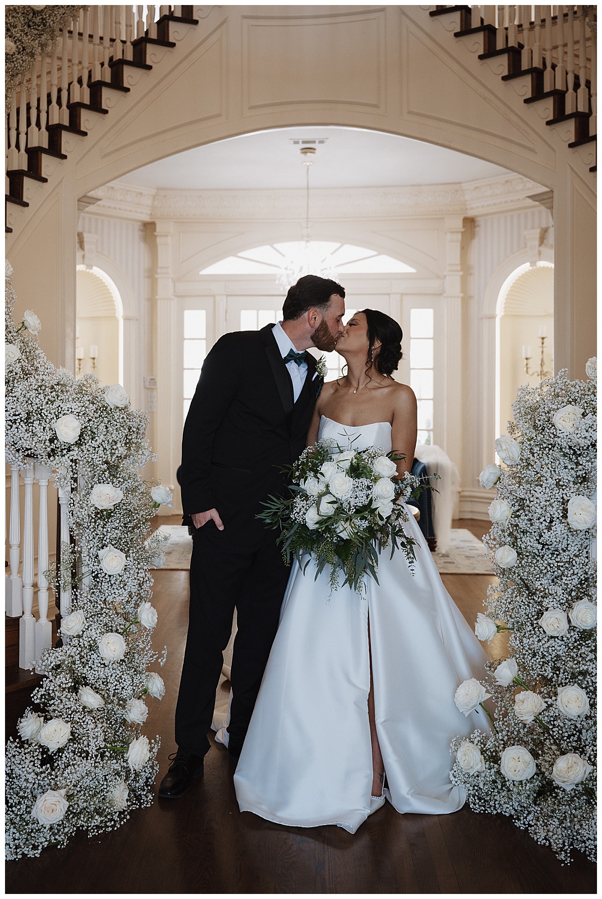 Classic bride & groom kissed at the bottom of the staircase