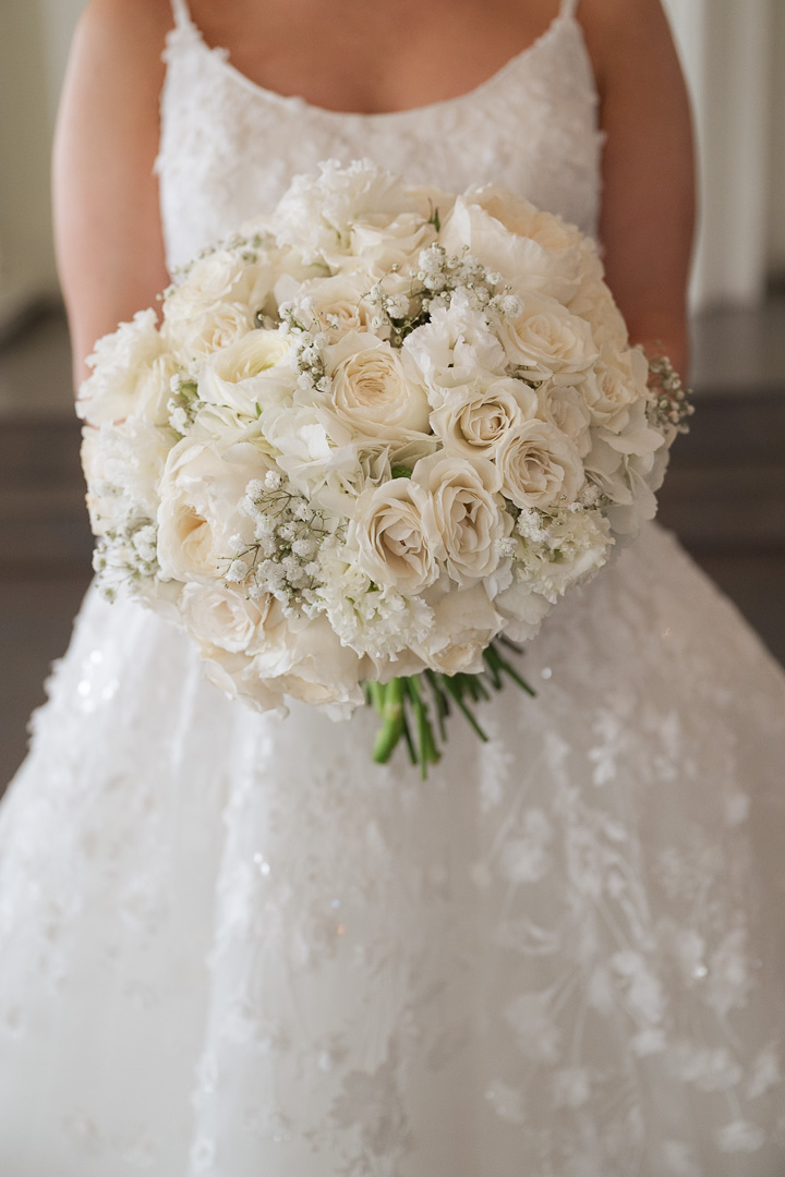 Elegant bride holding a floral bouquet during a Fort Worth wedding photographed by a Fort Worth wedding photographer